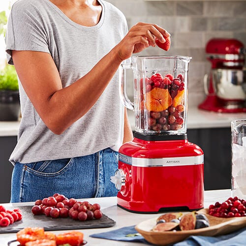 Close-up of red Kitchenaid blender and white Kitchenaid mixer on wooden  worktop below glass-ware on shelves in small kitchen Stock Photo - Alamy