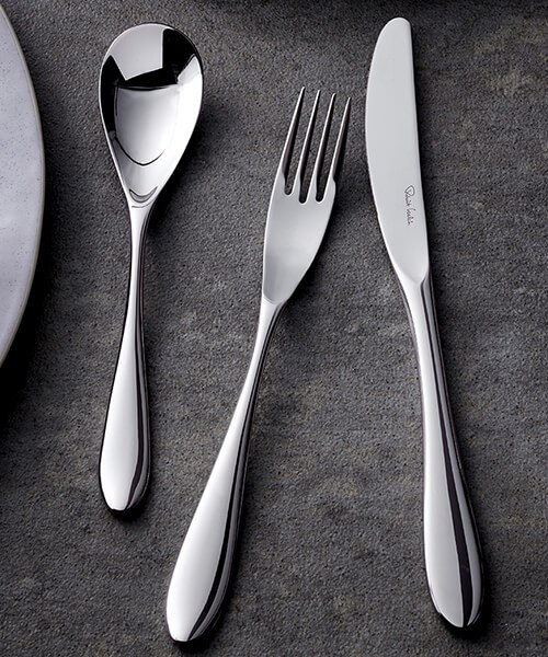 Contemporary stainless steel cutlery set on a dark background